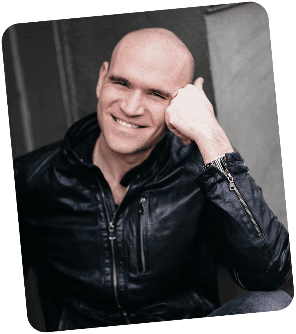 Michael Fabiano smiling in a leather jacket, leaning on one hand