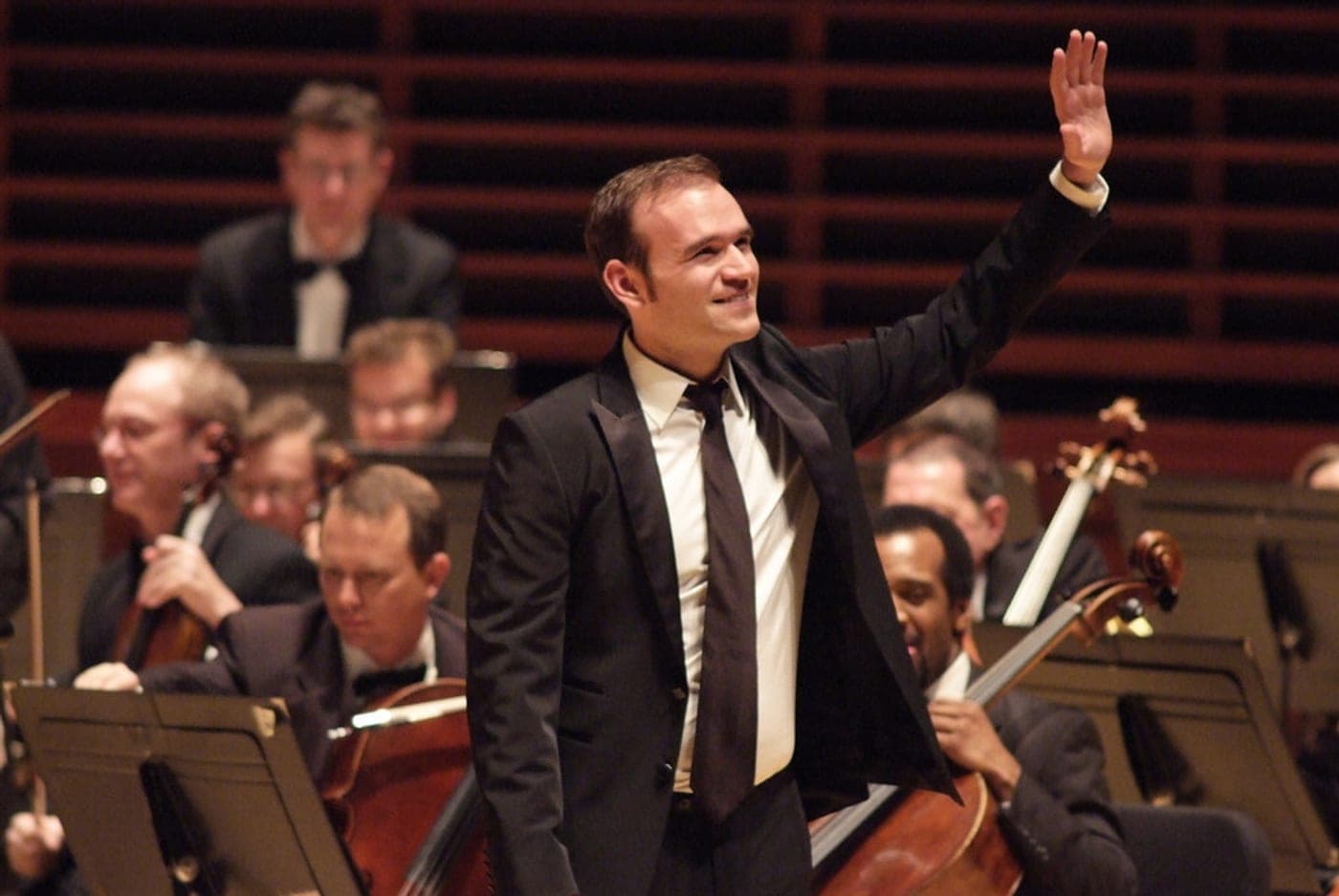 Michael Fabiano acknowledging applause on a concert stage in front of an orchestra